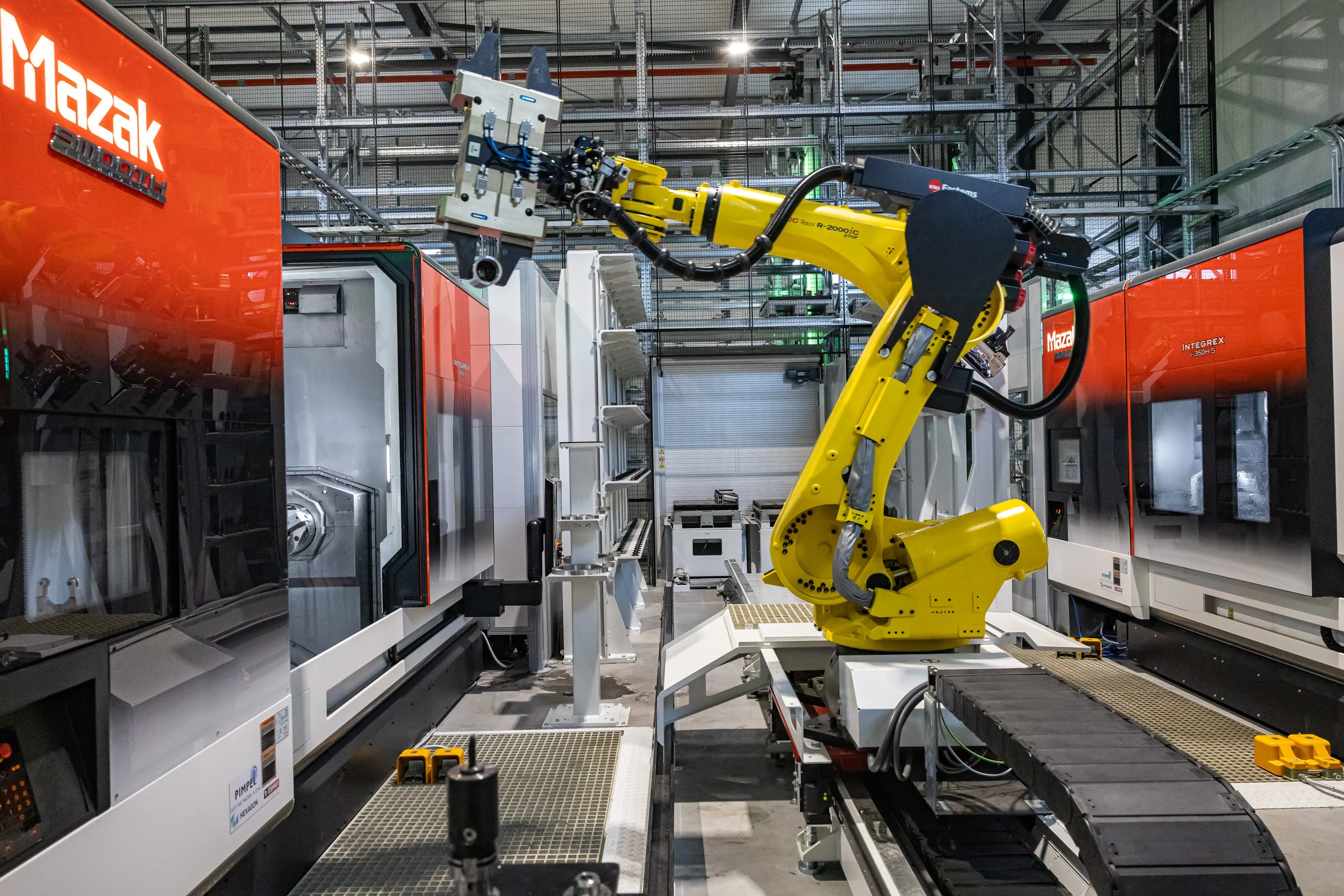 Gele robot op een rail tussen twee Mazak machines