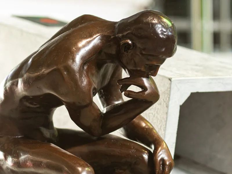 Een bronzen beeldje van De Denker van Rodin bij de ingang van RODIN machining